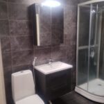 Kylpyhuone tummilla sävyvalinnoilla.